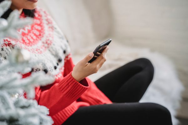 woman on holiday sweater on phone